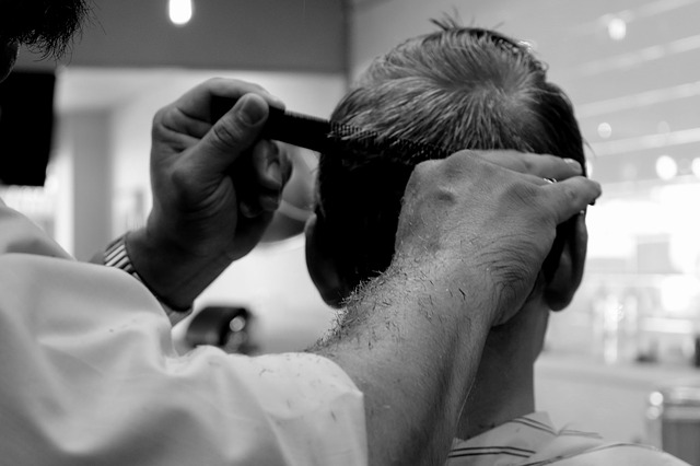 Imagem de um barbeiro cortando o cabelo de um cliente